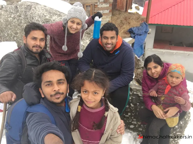 Trekking group and local children posing together in Barot Valley