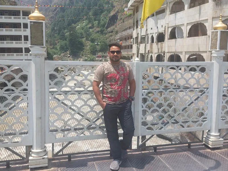 Tourist standing on the bridge over the Parvati River near Manikaran Sahib