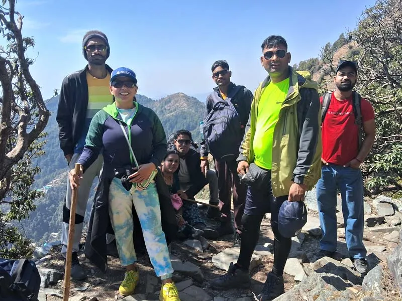 Trekkers posing together on a rocky trail with scenic Himalayan mountain views